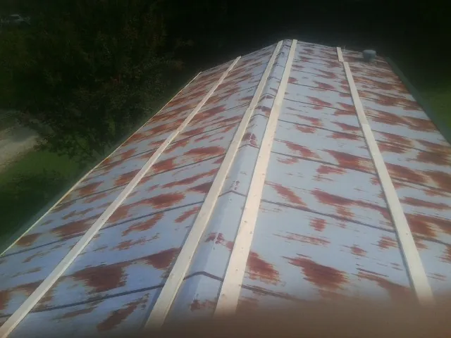 Rusted metal roof panels with new wood purlins before replacement — Storm Damage Roof Repair in Clare by Roofing Brothers